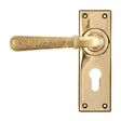 This is an image showing From The Anvil - Aged Brass Hammered Newbury Lever Euro Lock Set available from trade door handles, quick delivery and discounted prices