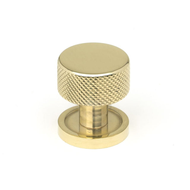 This is an image showing From The Anvil - Polished Brass Brompton Cabinet Knob - 25mm (Plain) available from trade door handles, quick delivery and discounted prices
