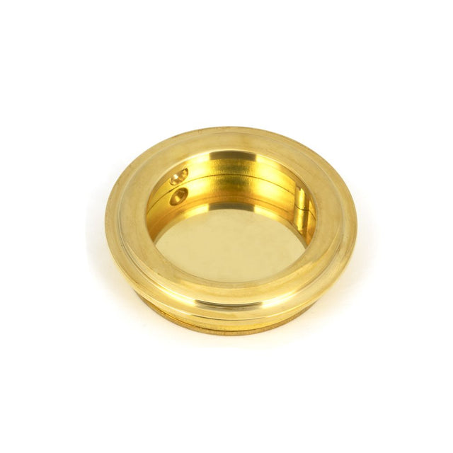 This is an image showing From The Anvil - Polished Brass 60mm Art Deco Round Pull available from trade door handles, quick delivery and discounted prices