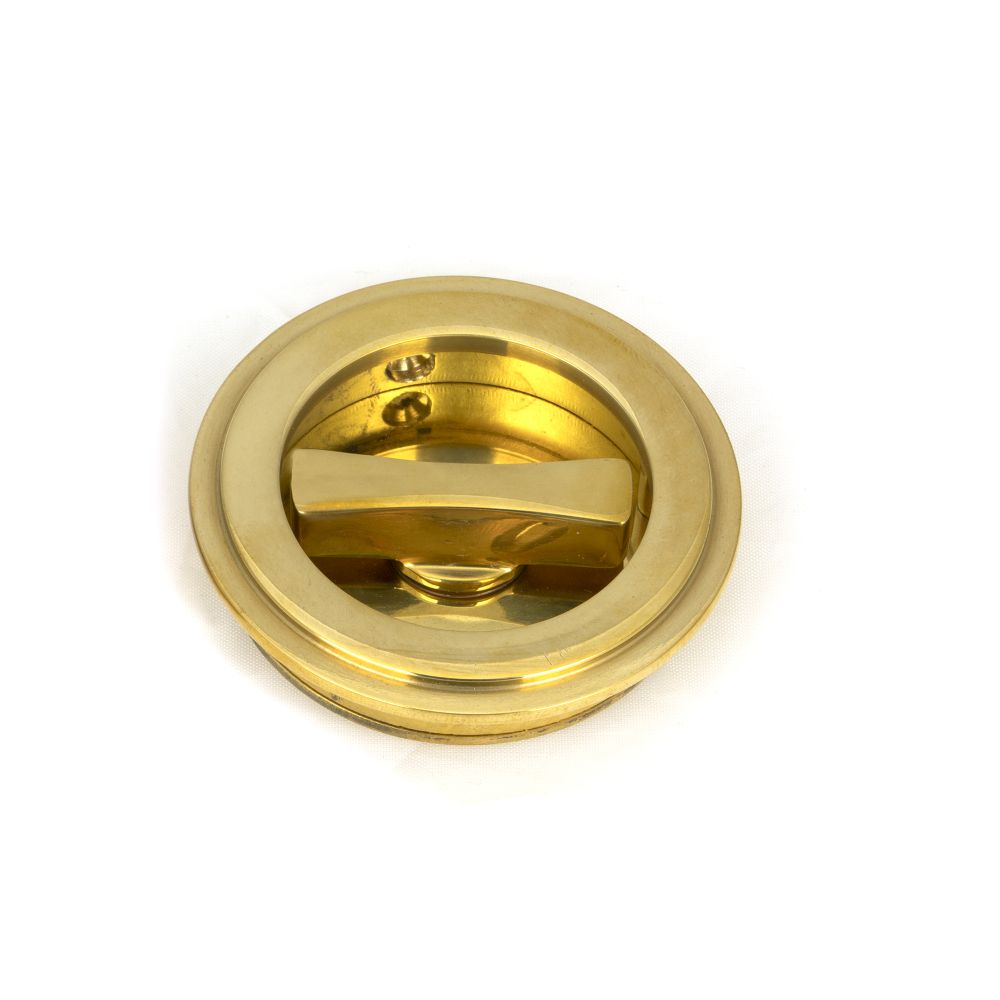 This is an image showing From The Anvil - Polished Brass 60mm Art Deco Round Pull - Privacy Set available from trade door handles, quick delivery and discounted prices