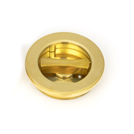 This is an image showing From The Anvil - Polished Brass 60mm Plain Round Pull - Privacy Set available from trade door handles, quick delivery and discounted prices