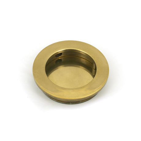 This is an image showing From The Anvil - Aged Brass 60mm Plain Round Pull available from trade door handles, quick delivery and discounted prices