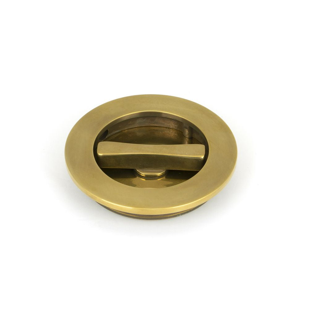 This is an image showing From The Anvil - Aged Brass 75mm Art Deco Round Pull - Privacy Set available from trade door handles, quick delivery and discounted prices