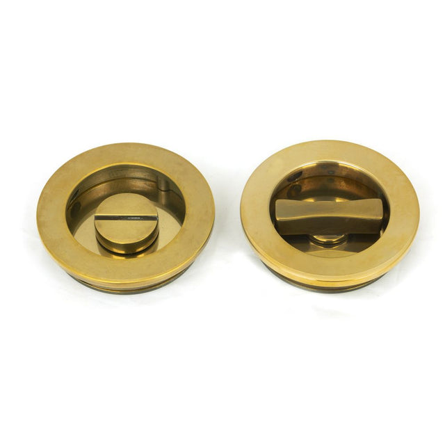 This is an image showing From The Anvil - Aged Brass 60mm Plain Round Pull - Privacy Set available from trade door handles, quick delivery and discounted prices