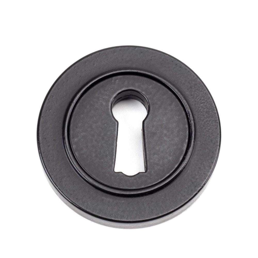 This is an image showing From The Anvil - Matt Black Round Escutcheon (Plain) available from trade door handles, quick delivery and discounted prices