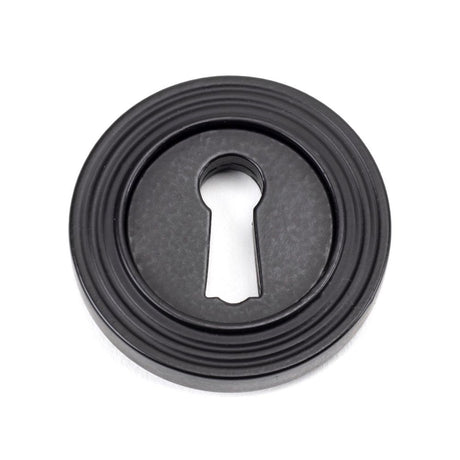 This is an image showing From The Anvil - Matt Black Round Escutcheon (Beehive) available from trade door handles, quick delivery and discounted prices