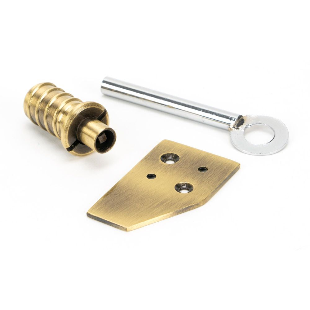 This is an image showing From The Anvil - Aged Brass Key-Flush Sash Stop available from trade door handles, quick delivery and discounted prices