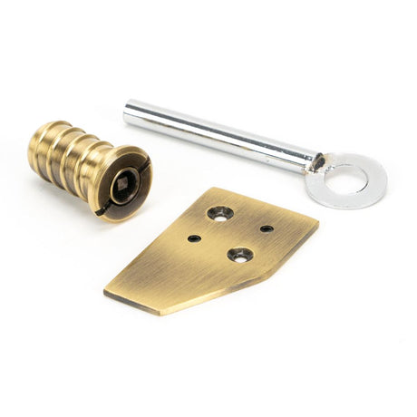 This is an image showing From The Anvil - Aged Brass Key-Flush Sash Stop available from trade door handles, quick delivery and discounted prices
