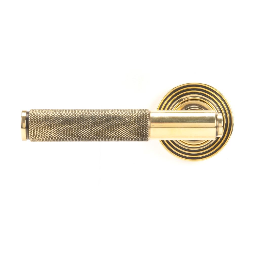 This is an image showing From The Anvil - Aged Brass Brompton Lever on Rose Set (Beehive) - Unsprung available from trade door handles, quick delivery and discounted prices