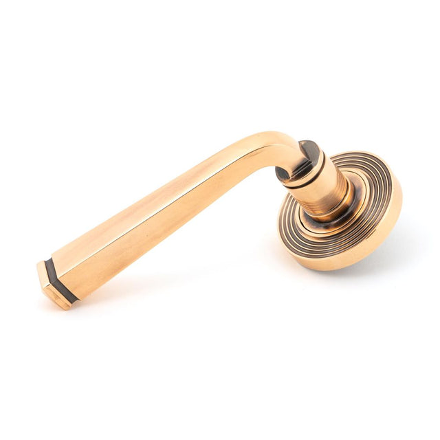 This is an image showing From The Anvil - Polished Bronze Avon Round Lever on Rose Set (Beehive) - Unspru available from trade door handles, quick delivery and discounted prices