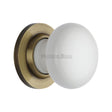 This is an image of a Heritage Brass - White Knob with Antique Brass base, 5010-at that is available to order from Trade Door Handles in Kendal.