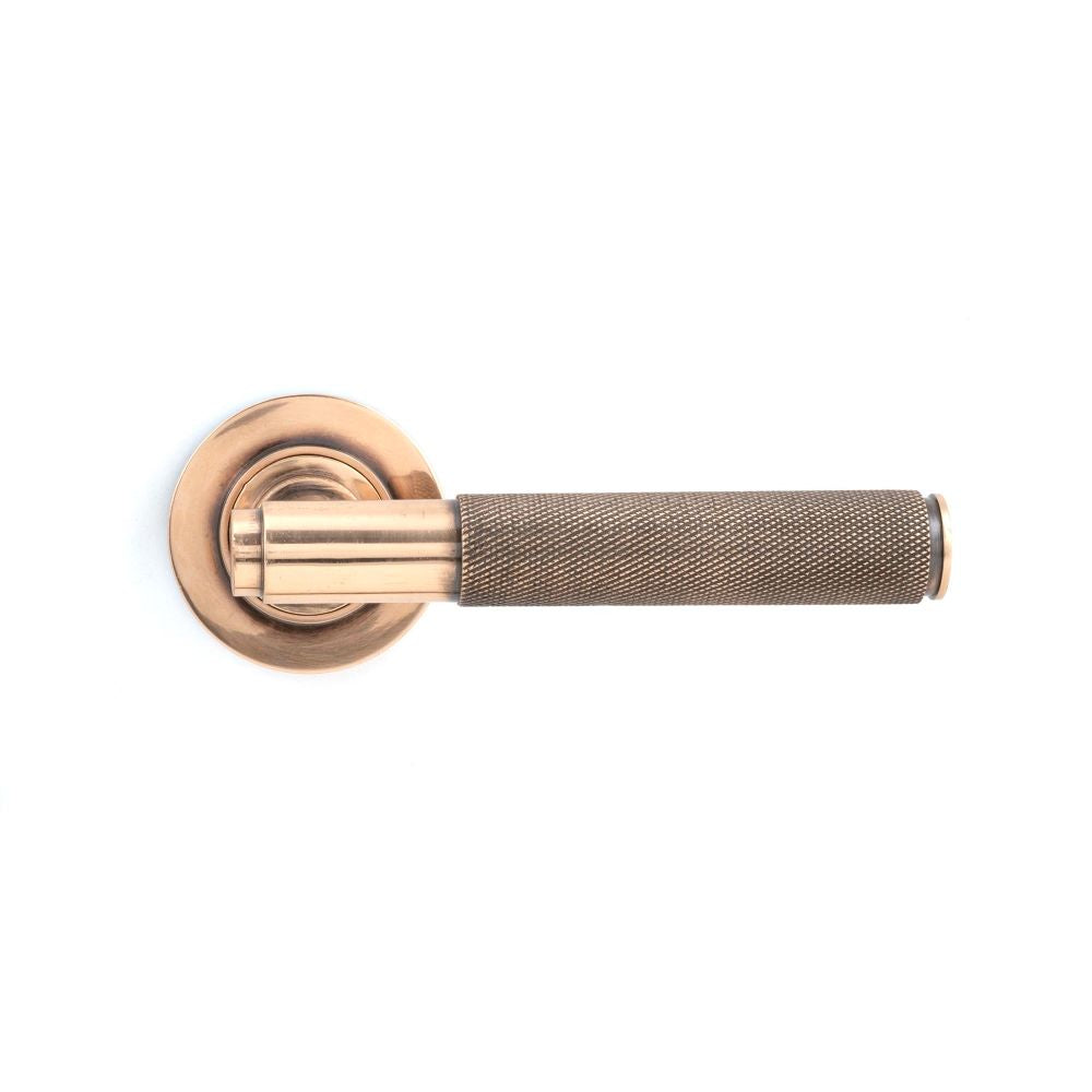 This is an image showing From The Anvil - Polished Bronze Brompton Lever on Rose Set (Plain) - Unsprung available from trade door handles, quick delivery and discounted prices