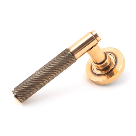 This is an image showing From The Anvil - Polished Bronze Brompton Lever on Rose Set (Plain) - Unsprung available from trade door handles, quick delivery and discounted prices