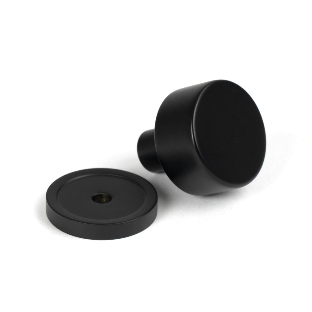 This is an image showing From The Anvil - Matt Black Kelso Cabinet Knob - 25mm (Plain) available from trade door handles, quick delivery and discounted prices