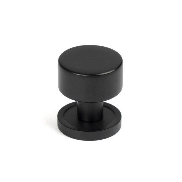 This is an image showing From The Anvil - Matt Black Kelso Cabinet Knob - 25mm (Plain) available from trade door handles, quick delivery and discounted prices