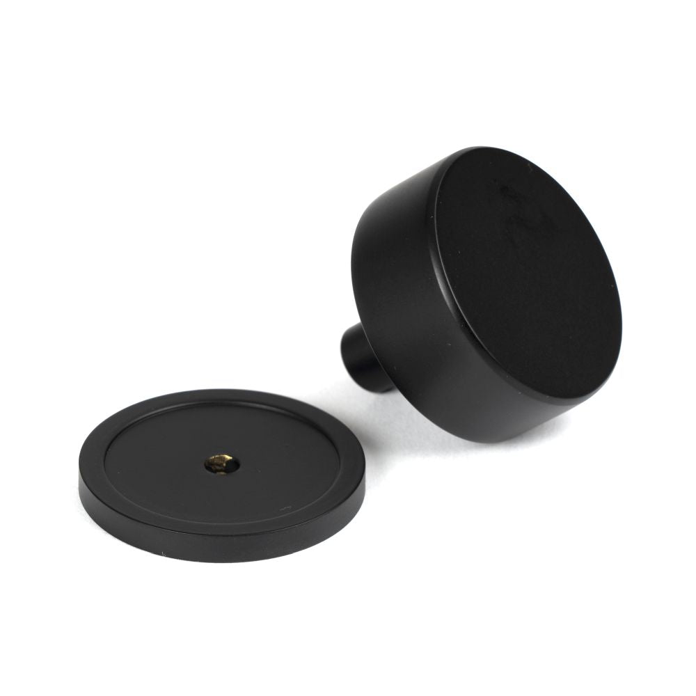 This is an image showing From The Anvil - Matt Black Kelso Cabinet Knob - 38mm (Plain) available from trade door handles, quick delivery and discounted prices