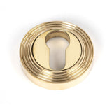 This is an image showing From The Anvil - Polished Brass Round Euro Escutcheon (Beehive) available from trade door handles, quick delivery and discounted prices