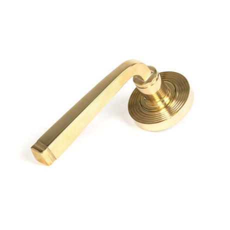 This is an image showing From The Anvil - Polished Brass Avon Round Lever on Rose Set (Beehive) available from trade door handles, quick delivery and discounted prices