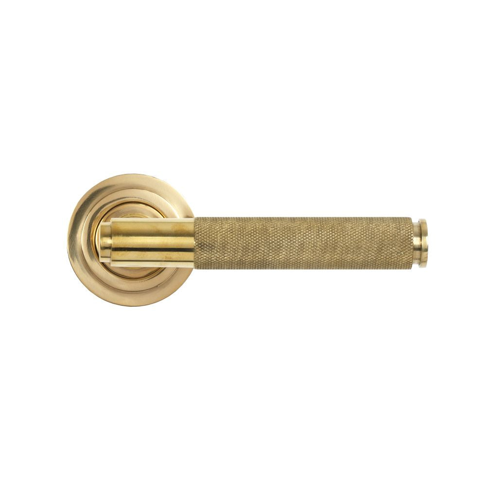 This is an image showing From The Anvil - Polished Brass Brompton Lever on Rose Set (Art Deco) available from trade door handles, quick delivery and discounted prices