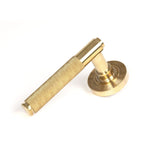 This is an image showing From The Anvil - Polished Brass Brompton Lever on Rose Set (Beehive) available from trade door handles, quick delivery and discounted prices