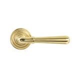 This is an image showing From The Anvil - Polished Brass Newbury Lever on Rose Set (Art Deco) available from trade door handles, quick delivery and discounted prices