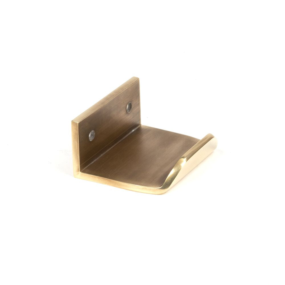 This is an image showing From The Anvil - Aged Brass 50mm Moore Edge Pull available from trade door handles, quick delivery and discounted prices