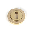 This is an image showing From The Anvil - Polished Brass Round Escutcheon (Plain) available from trade door handles, quick delivery and discounted prices