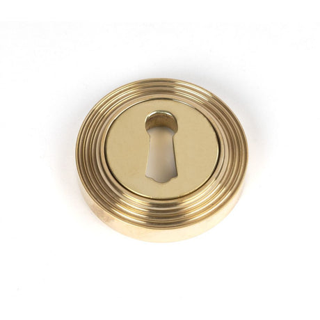 This is an image showing From The Anvil - Polished Brass Round Escutcheon (Beehive) available from trade door handles, quick delivery and discounted prices