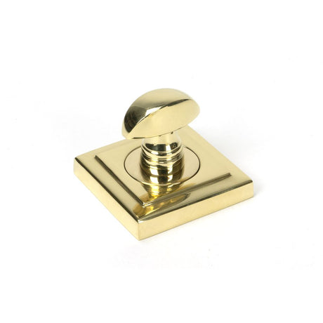 This is an image showing From The Anvil - Polished Brass Round Thumbturn Set (Square) available from trade door handles, quick delivery and discounted prices