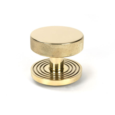 This is an image showing From The Anvil - Polished Brass Brompton Centre Door Knob (Beehive) available from trade door handles, quick delivery and discounted prices