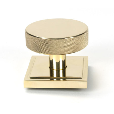 This is an image showing From The Anvil - Polished Brass Brompton Centre Door Knob (Square) available from trade door handles, quick delivery and discounted prices