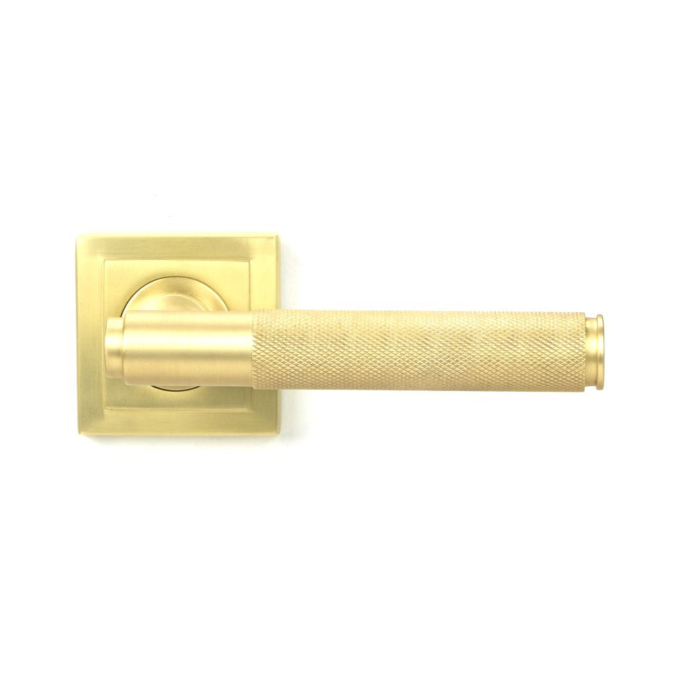 This is an image showing From The Anvil - Satin Brass Brompton Lever on Rose Set (Square) available from trade door handles, quick delivery and discounted prices