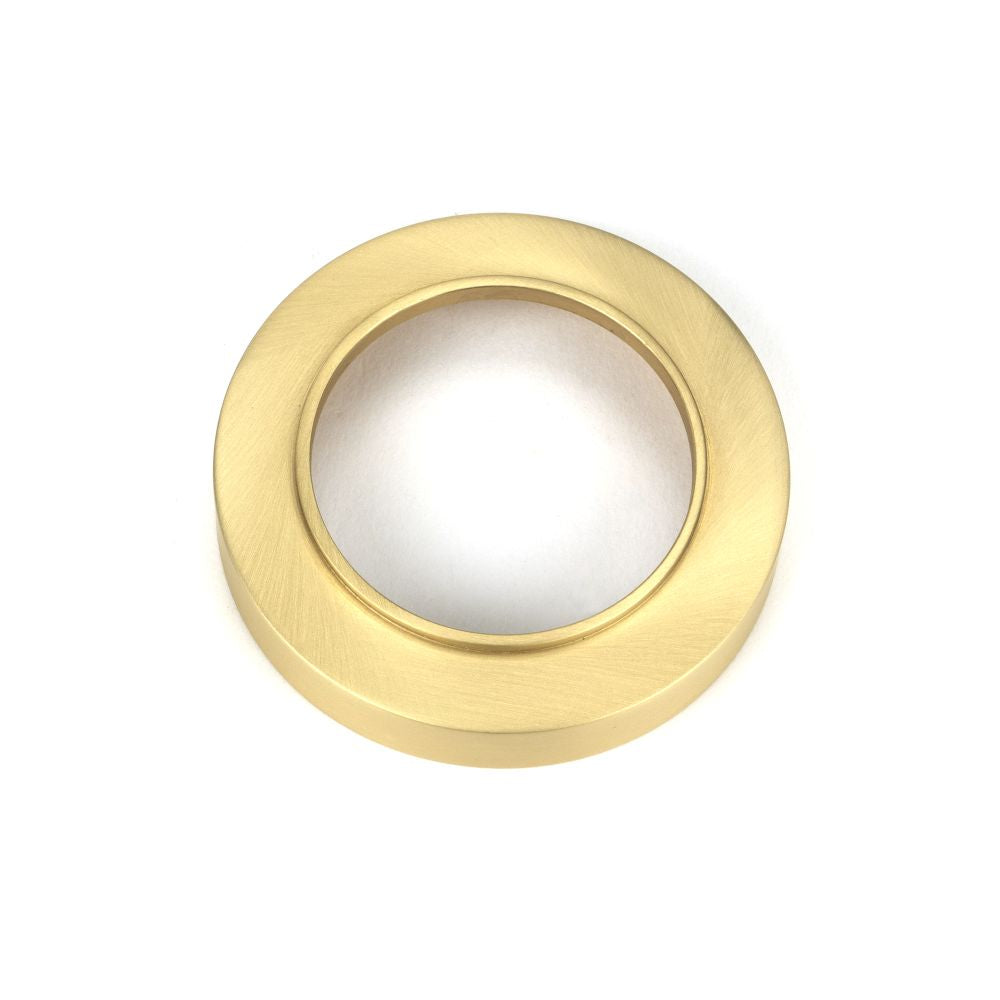 This is an image showing From The Anvil - Satin Brass Round Escutcheon (Plain) available from trade door handles, quick delivery and discounted prices