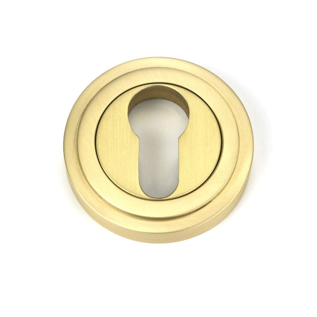 This is an image showing From The Anvil - Satin Brass Round Euro Escutcheon (Art Deco) available from trade door handles, quick delivery and discounted prices