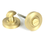 This is an image showing From The Anvil - Satin Brass Round Thumbturn Set (Plain) available from trade door handles, quick delivery and discounted prices