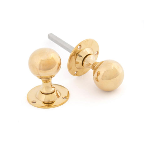This is an image showing From The Anvil - Polished Brass Ball Mortice Knob Set available from trade door handles, quick delivery and discounted prices