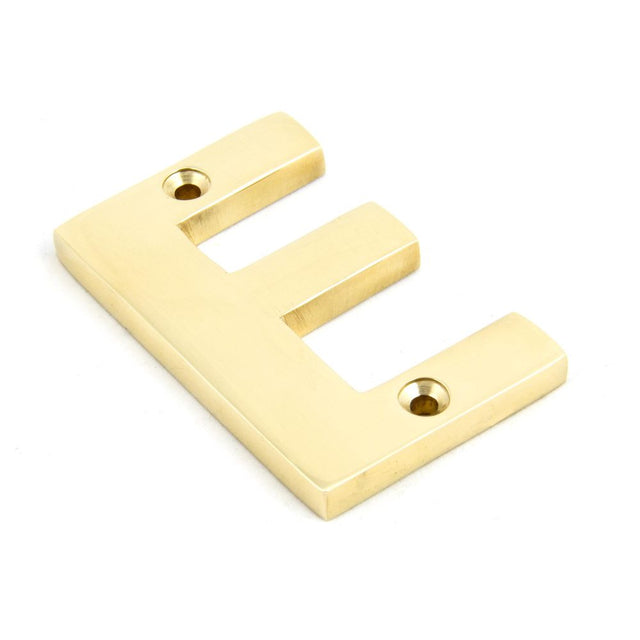 This is an image showing From The Anvil - Polished Brass Letter E available from trade door handles, quick delivery and discounted prices