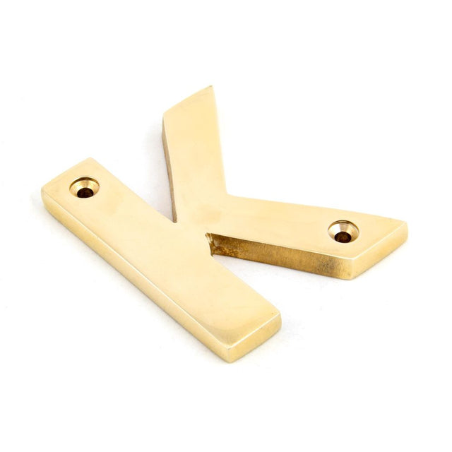 This is an image showing From The Anvil - Polished Brass Letter K available from trade door handles, quick delivery and discounted prices