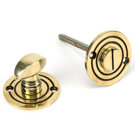 This is an image showing From The Anvil - Aged Brass Round Bathroom Thumbturn available from trade door handles, quick delivery and discounted prices
