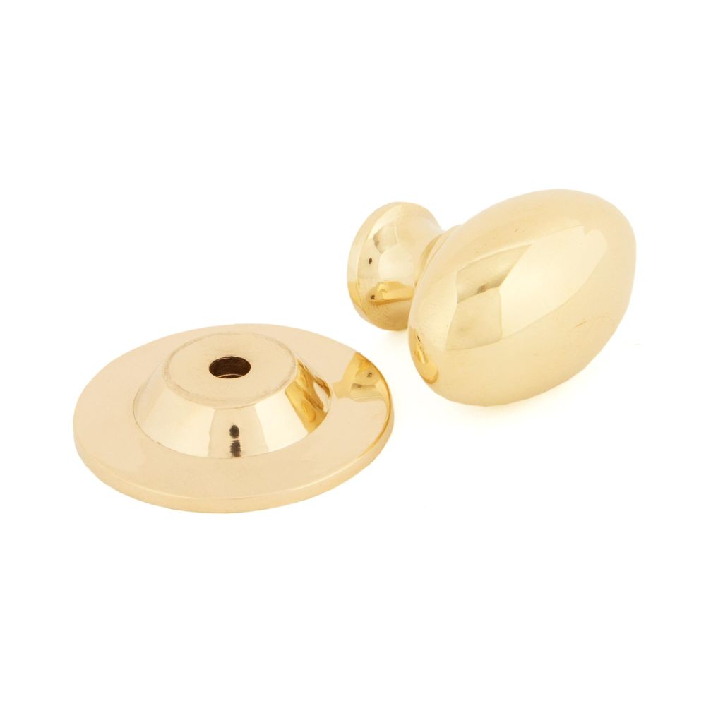 This is an image showing From The Anvil - Polished Brass Oval Cabinet Knob 33mm available from trade door handles, quick delivery and discounted prices