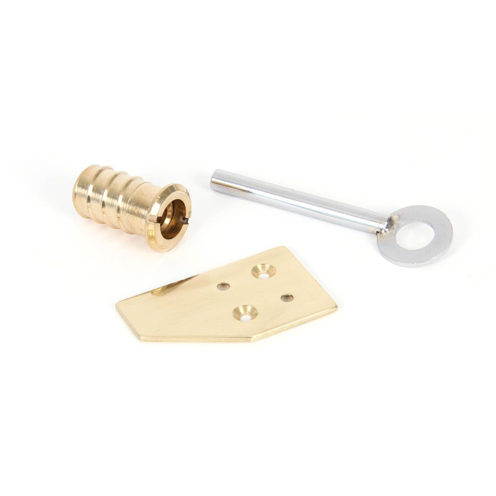 This is an image showing From The Anvil - Polished Brass Key-Flush Sash Stop available from trade door handles, quick delivery and discounted prices