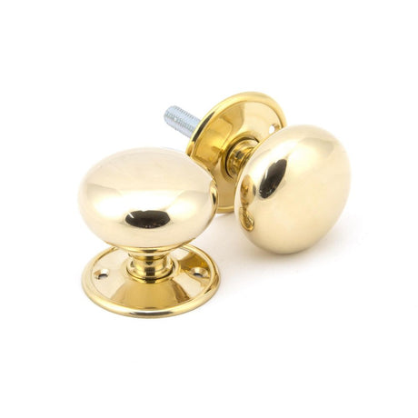 This is an image showing From The Anvil - Polished Brass 57mm Mushroom Mortice/Rim Knob Set available from trade door handles, quick delivery and discounted prices