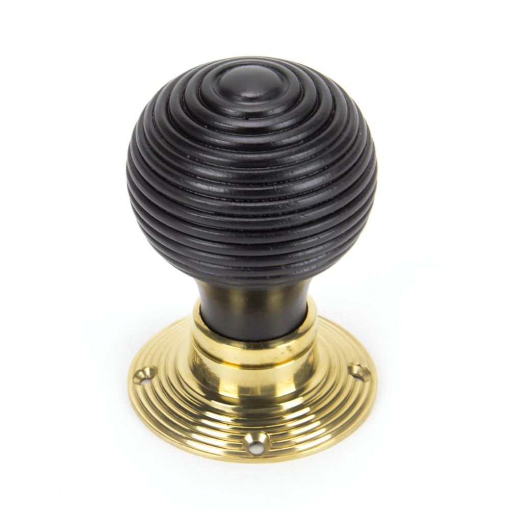 This is an image showing From The Anvil - Ebony & Polished Brass Beehive Mortice/Rim Knob Set available from trade door handles, quick delivery and discounted prices