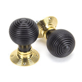 This is an image showing From The Anvil - Ebony & Polished Brass Beehive Mortice/Rim Knob Set available from trade door handles, quick delivery and discounted prices