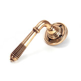 This is an image showing From The Anvil - Polished Bronze Reeded Lever on Rose Set available from trade door handles, quick delivery and discounted prices