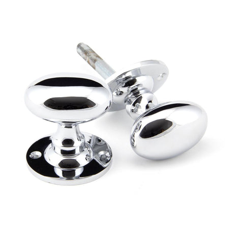 This is an image showing From The Anvil - Polished Chrome Oval Mortice/Rim Knob Set available from trade door handles, quick delivery and discounted prices