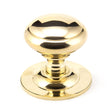 This is an image showing From The Anvil - Polished Brass Round Centre Door Knob available from trade door handles, quick delivery and discounted prices