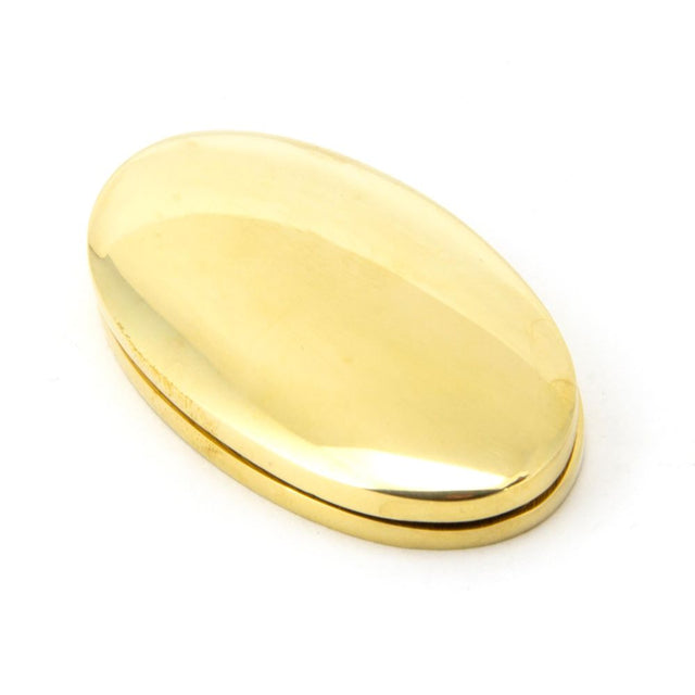 This is an image showing From The Anvil - Polished Brass Oval Escutcheon & Cover available from trade door handles, quick delivery and discounted prices