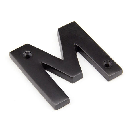 This is an image showing From The Anvil - Aged Bronze Letter M available from trade door handles, quick delivery and discounted prices