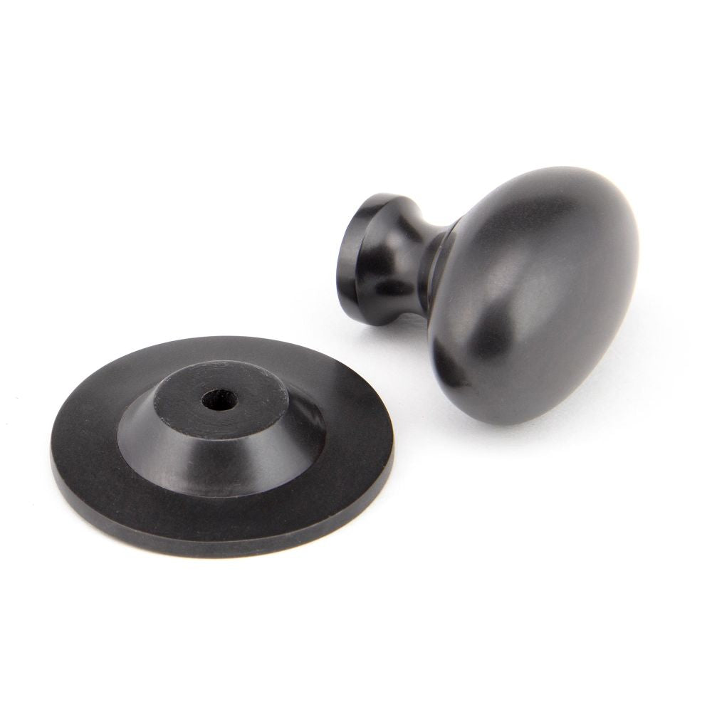 This is an image showing From The Anvil - Aged Bronze Oval Cabinet Knob 40mm available from trade door handles, quick delivery and discounted prices